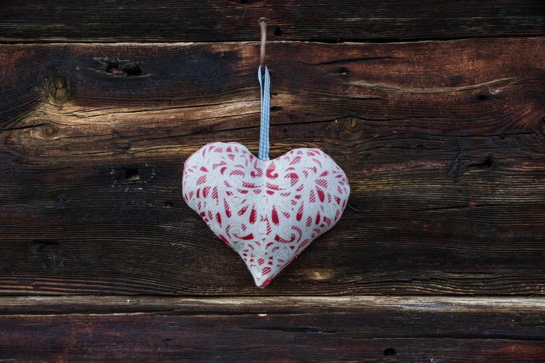 a red and white heart hanging on a wooden wall, inspired by Louise Bourgeois, folk art, emma bridgewater and paperchase, linen, peppermint motif, pine