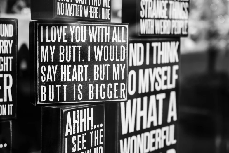 a sign that says i love you with all my butt i would not say heart but i, a black and white photo, signboards, looking at each other mindlessly, hight decorated, bum