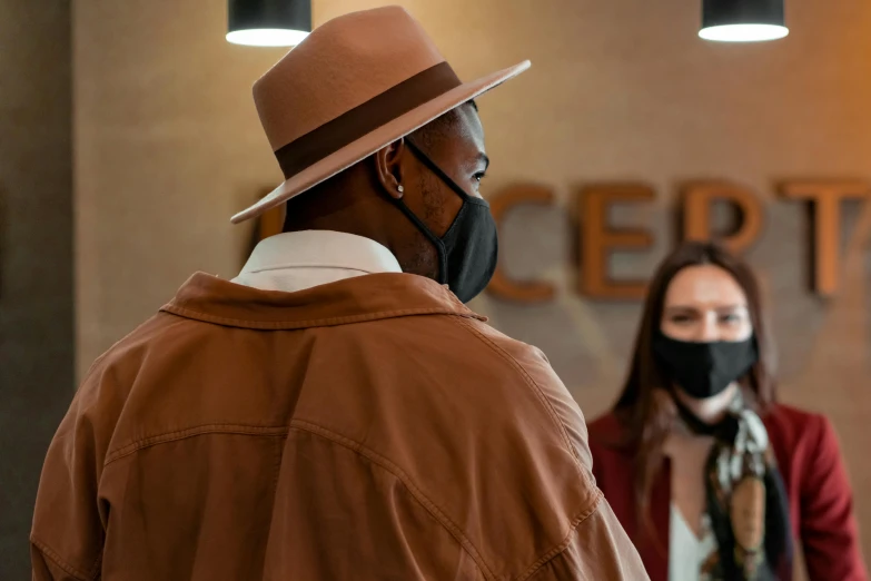 a man in a hat and a woman wearing a face mask, by Mike Bierek, pexels contest winner, hyperrealism, kobe bryant, wearing a brown, appearing in a shopping mall, standing in a restaurant
