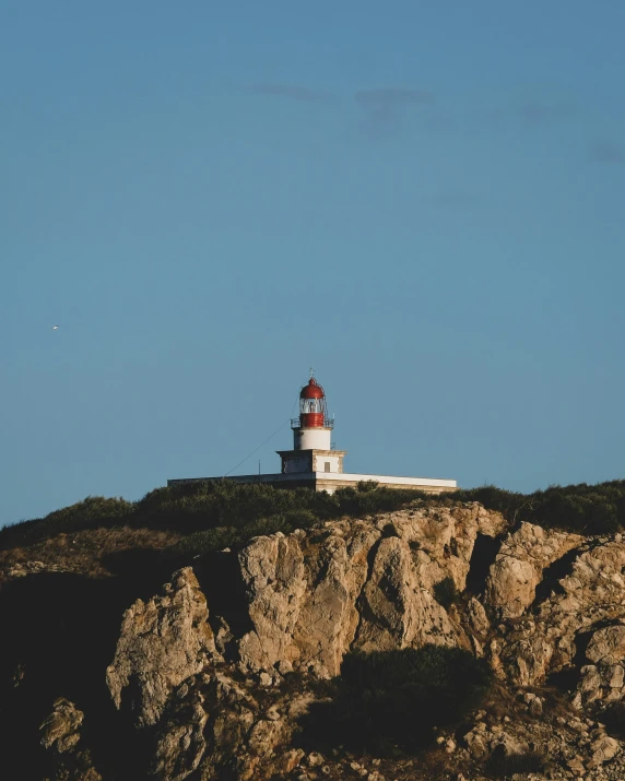 a lighthouse sitting on top of a rocky cliff, on the top of a hill, lgbtq, trending on vsco, portugal