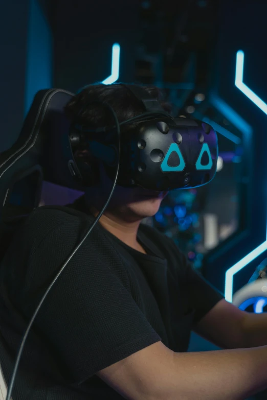 a man sitting in front of a computer wearing a virtual reality headset, happening, space hive, riot entertainment, pictured from the shoulders up, helmet view