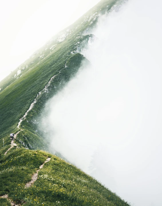 a man standing on top of a lush green hillside, pexels contest winner, romanticism, trailing white vapor, in the swiss alps, be running up that hill, snapchat photo