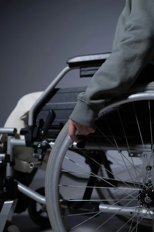 a close up of a person in a wheel chair, hurufiyya, on a gray background, mechanics, softly lit, bracts