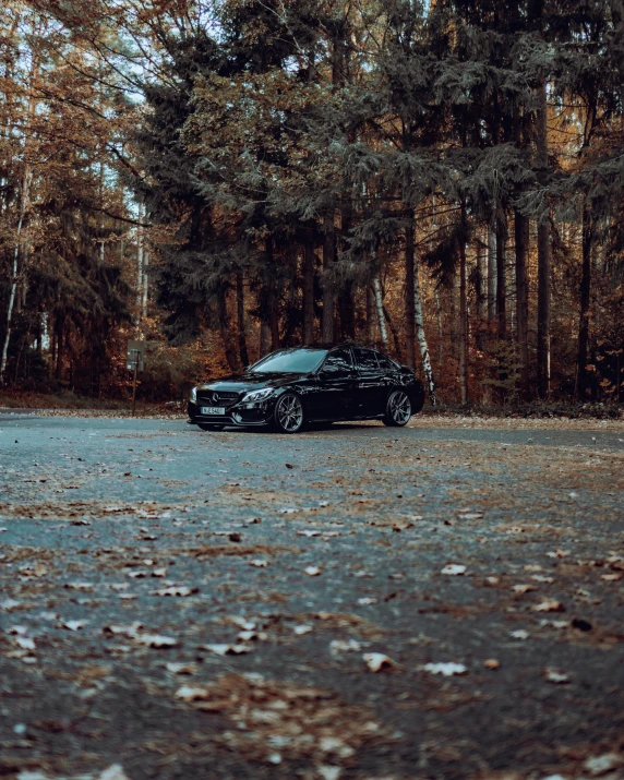 a black car parked on the side of a road, by Sebastian Spreng, pexels contest winner, sitting in the forrest, bentley, 🍂 cute, today\'s featured photograph 4k