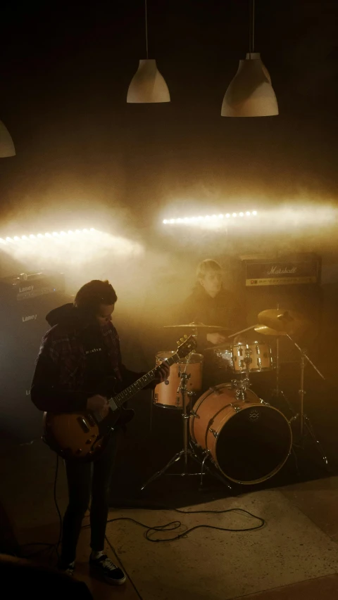 a man playing a guitar in a dimly lit room, heavy rock band promo photo, worksafe. cinematic, the scooter ( edm band, drums