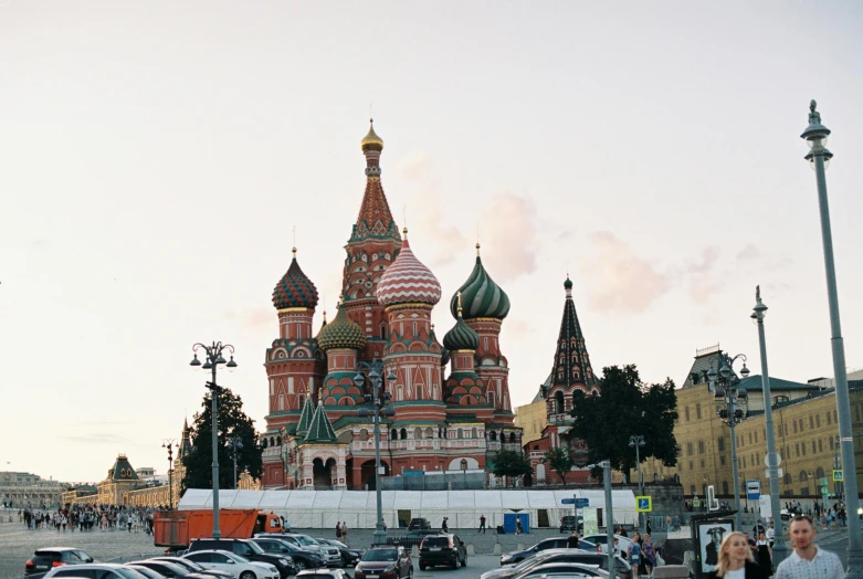 a group of people standing in front of a building, inspired by Vasily Surikov, unsplash contest winner, black domes and spires, square, early evening, 🚿🗝📝