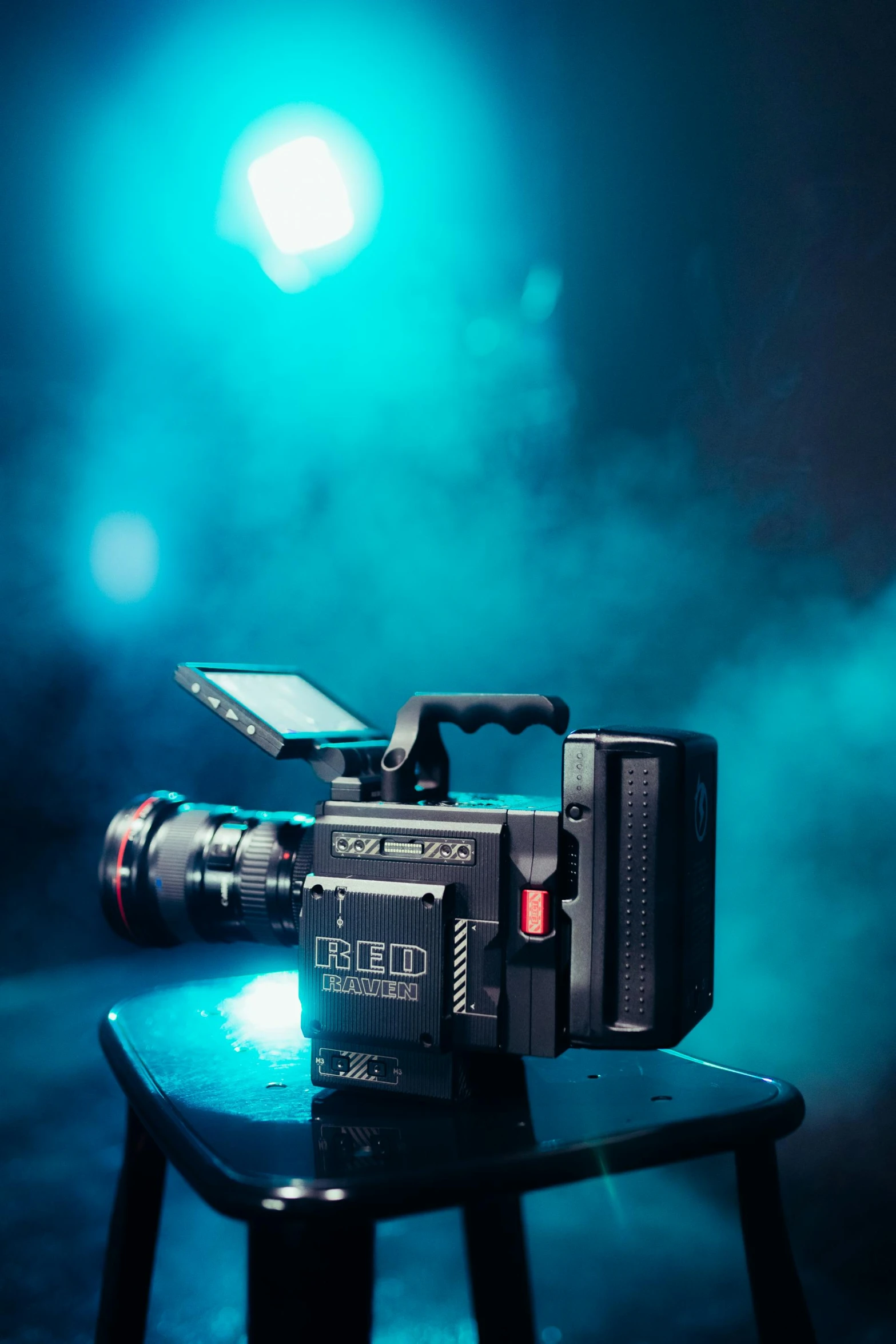 a video camera sitting on top of a table, a portrait, inspired by roger deakins, red magic, 8 k epic scene, cinematic blue lighting, cinematic photo shoot