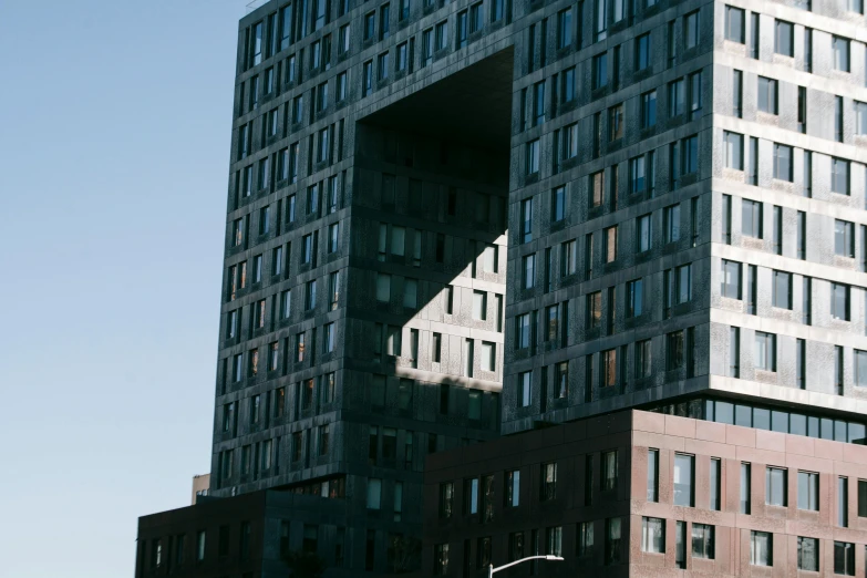 a very tall building sitting in the middle of a city, by Jakob Emanuel Handmann, unsplash, brutalism, harlem, cube portals, bjarke ingels, large open windows