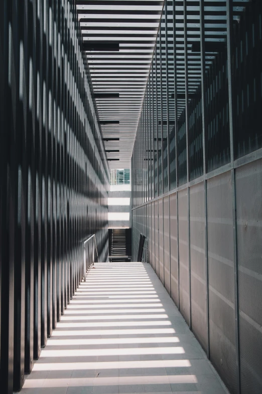 a long hallway in a building with lots of windows, inspired by David Chipperfield, pexels contest winner, perforated metal, high angle vertical, an approaching shadow, stairs