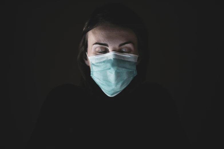 a woman wearing a face mask in the dark, pexels, hyperrealism, nurse, sickness, avatar image, atmospheric photo