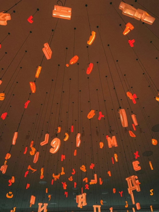 a bunch of lights hanging from the ceiling of a building, by Bruce Munro, unsplash contest winner, interactive art, orange tones, alphabet soup, equation heaven, profile image