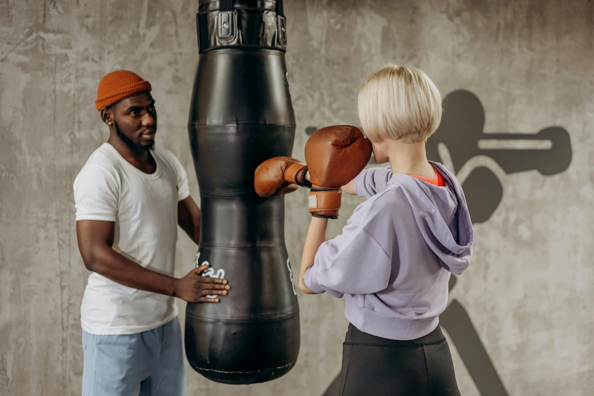 a man and a woman standing in front of a punching bag, pexels contest winner, hurufiyya, thumbnail, background image, working out, decorative