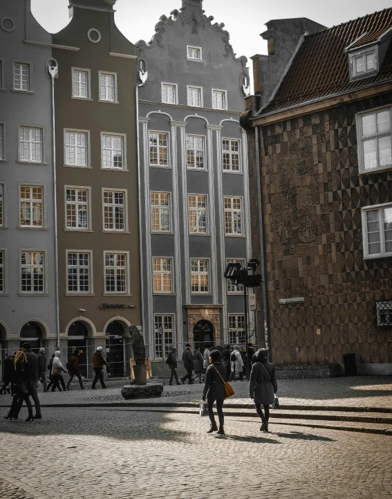 a group of people walking down a cobblestone street, by Emma Andijewska, pexels contest winner, renaissance, modernist buildings, denmark, desaturated color, listing image