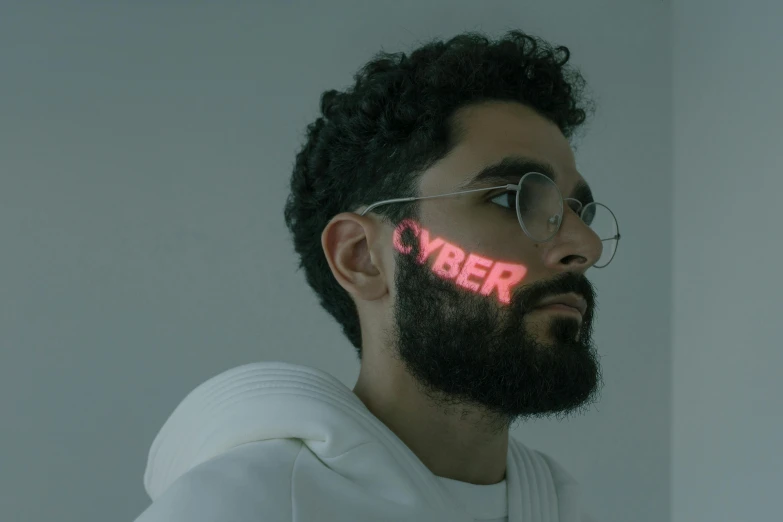 a man with a beard and glasses with the word cyber written on his face, an album cover, inspired by Ahmed Yacoubi, trending on pexels, hyperrealism, glowing white lasers, computer aesthetic, cyborg fashion model, laser light *