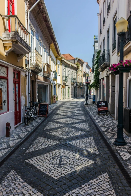 a cobblestone street in a european city, inspired by Samuel Silva, azores, white marble buildings, wooden houses, patterned tilework