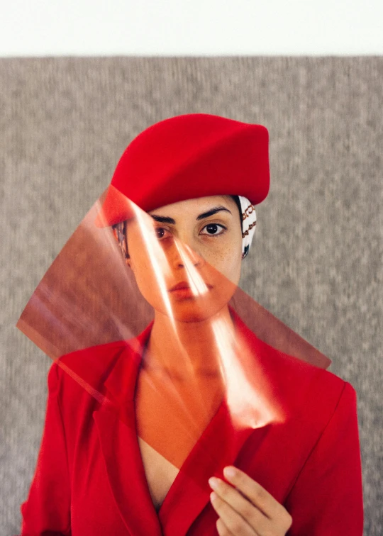 a woman in a red suit holding a mirror, an album cover, inspired by Scarlett Hooft Graafland, pexels contest winner, fine art, turban, ana de la reguera portrait, red uniform, transparent veil