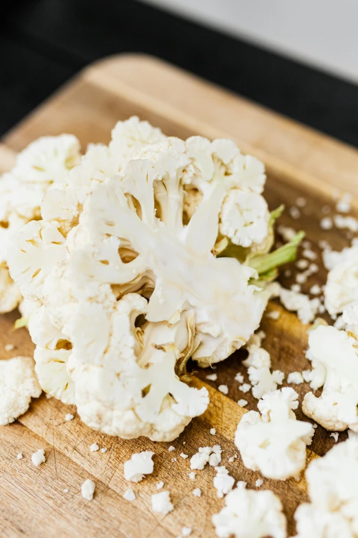 a wooden cutting board topped with pieces of cauliflower, a portrait, by Carey Morris, unsplash, intense albino, vanilla, 15081959 21121991 01012000 4k, patagonian