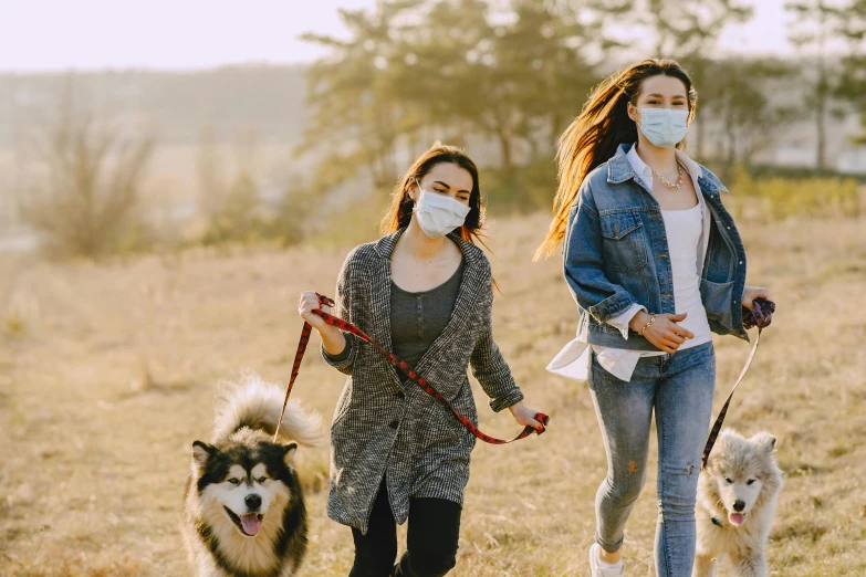 two women walking their dogs wearing face masks, a picture, by Emma Andijewska, shutterstock, renaissance, sydney park, teenager, surgery, unsplash contest winning photo