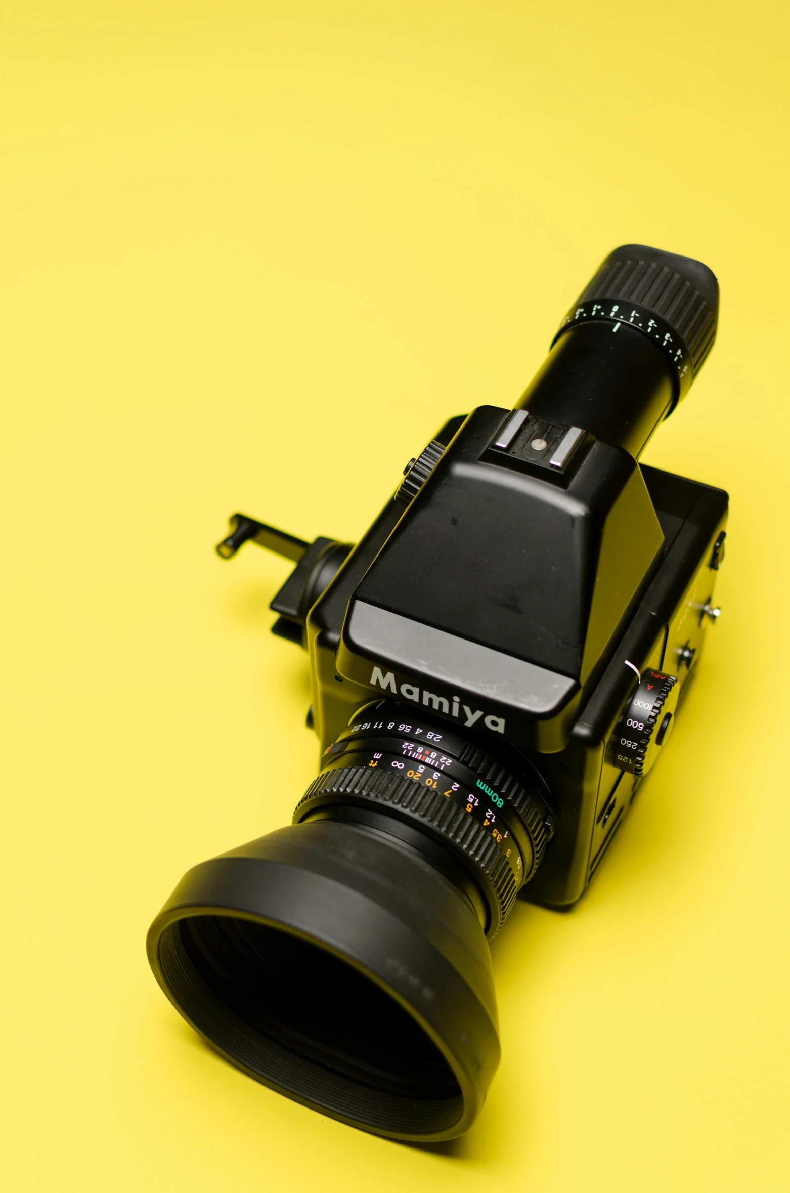 a camera sitting on top of a yellow surface, monocular, mamiya rb 6 7, detailed high resolution, large format