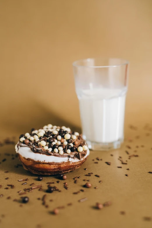 a donut sitting next to a glass of milk, by Nina Hamnett, pexels, hurufiyya, 256x256, chocolate. rugged, seeds, goat