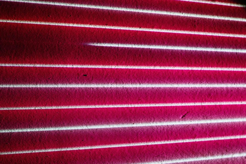 a close up of a red wall with light coming through it, by Doug Ohlson, pink neon lights, striations, ((pink)), white neon wash