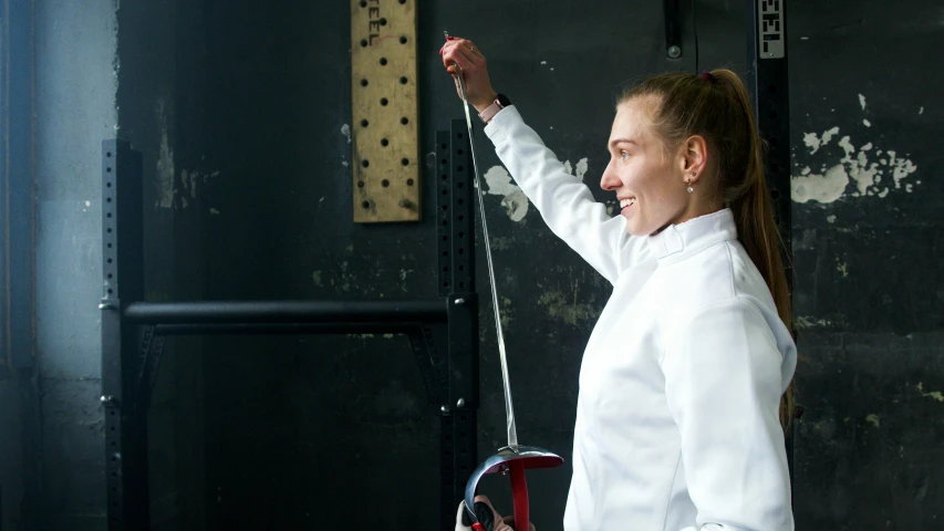 a woman in a white shirt holding a sword, competition winning, smiling, profile image, max prentis