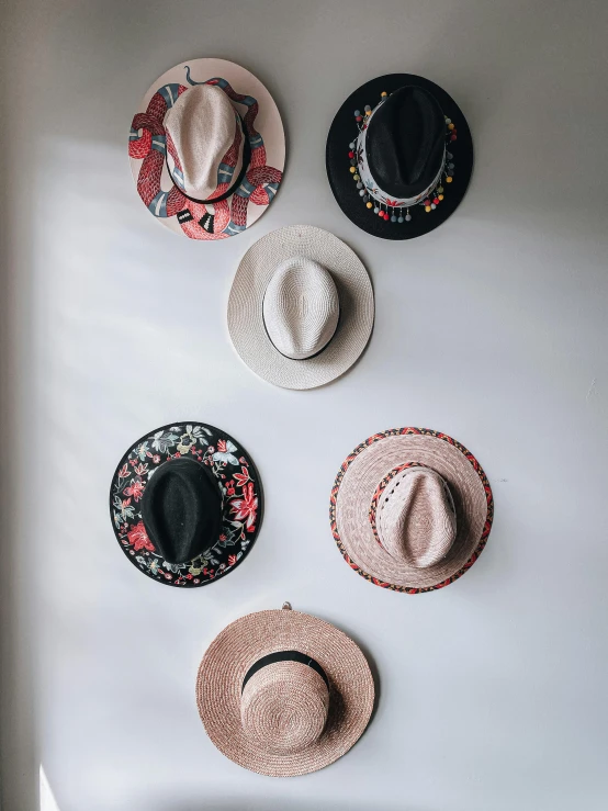 a bunch of hats hanging on a wall, a picture, by Carey Morris, trending on unsplash, pink cowboy hat, flatlay, high quality photo, facing front