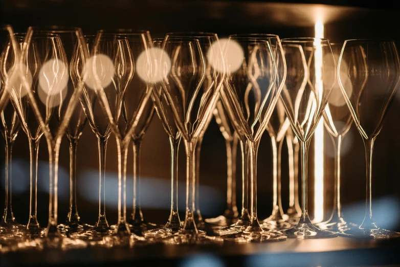 a bunch of wine glasses sitting on top of a table, pexels contest winner, precisionism, pur champagne damery, glowing details, thumbnail, glass openings