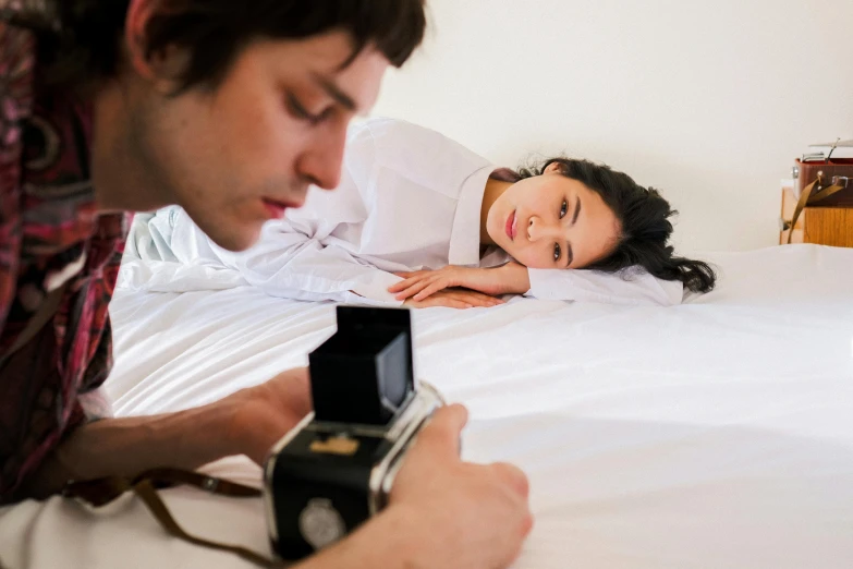 a man taking a picture of a woman laying in bed, inspired by Lucian Freud, pexels contest winner, studio medium format photograph, scientific photo, cute photograph, japanese