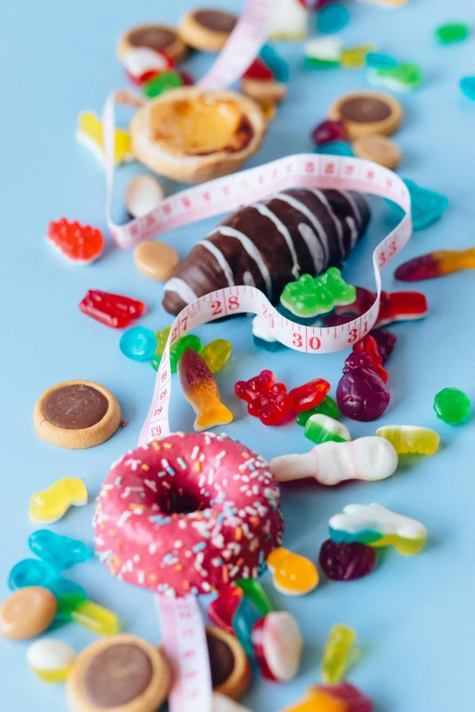 a donut with a measuring tape on top of it, a still life, by Julia Pishtar, pexels contest winner, made of candy and lollypops, full body close-up shot, gummy bears, 15081959 21121991 01012000 4k