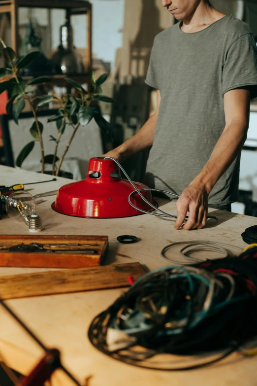 a man that is standing in front of a table, trending on pexels, process art, red hot soldering iron, wires and lights, detailed product image, vintage aesthetic
