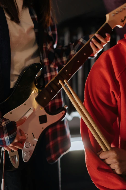 a man standing next to a woman holding a guitar, zoomed in, rock band, neck zoomed in, demo scene