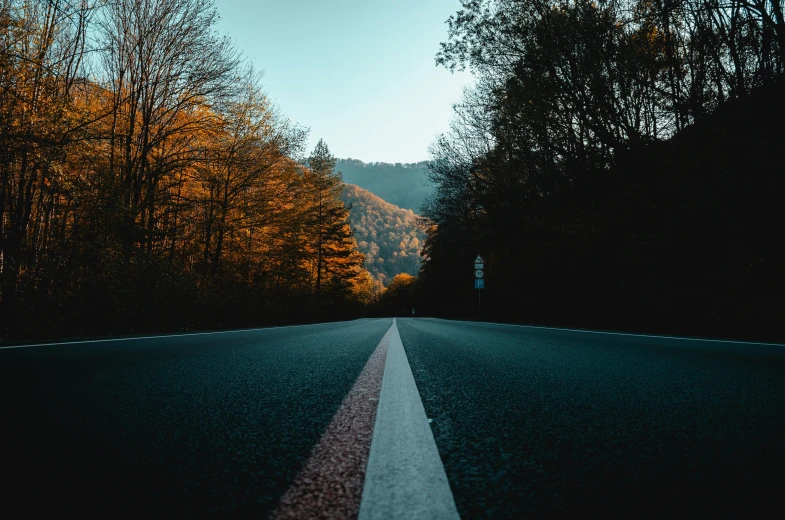 an empty road in the middle of a forest, pexels contest winner, teal and orange colors, hills in the background, thumbnail, black