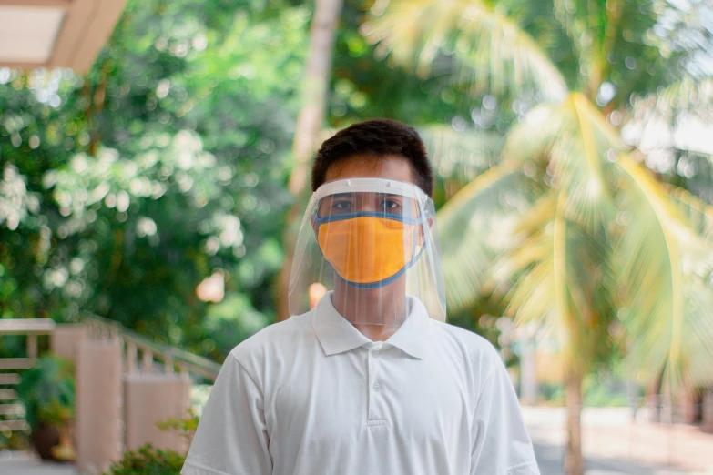 a man wearing a face shield with palm trees in the background, a picture, pexels, visual art, set on singaporean aesthetic, avatar image, full frontal shot, college