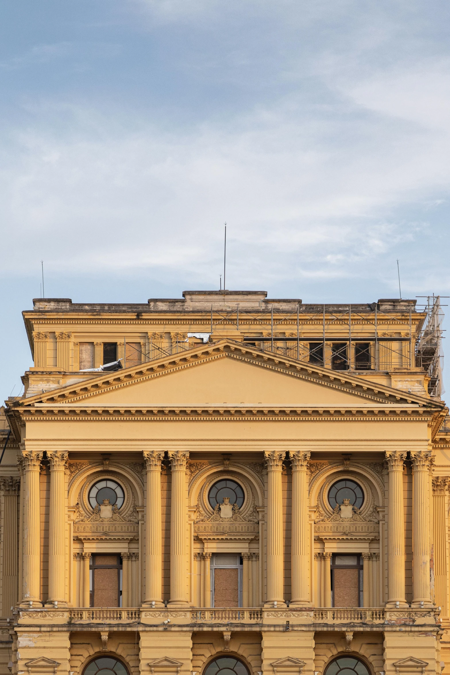 a large building with a clock tower in front of it, inspired by Mihály Munkácsy, neoclassicism, buenos aires, under repairs, theater, pictured from the shoulders up