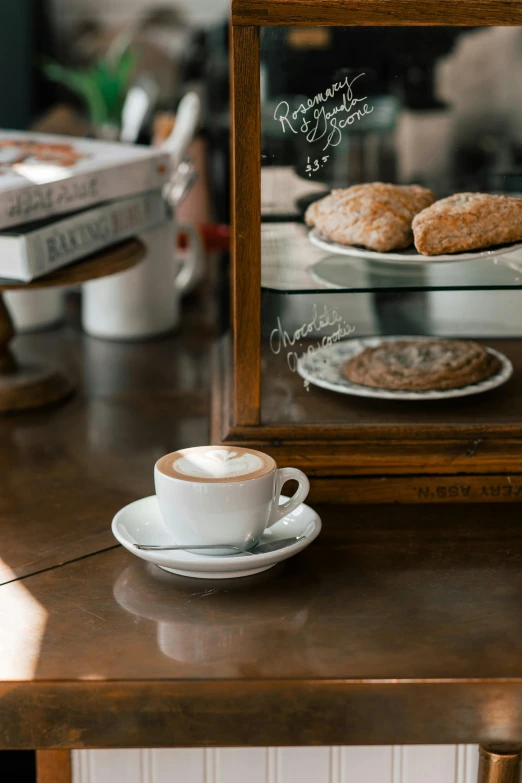 a wooden table topped with plates of food and a cup of coffee, bakery, profile image, san francisco, cappuccino