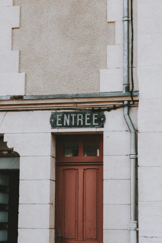 a red door that is on the side of a building, pexels contest winner, art nouveau, street signs, french village interior, real vintage photo, small town surrounding