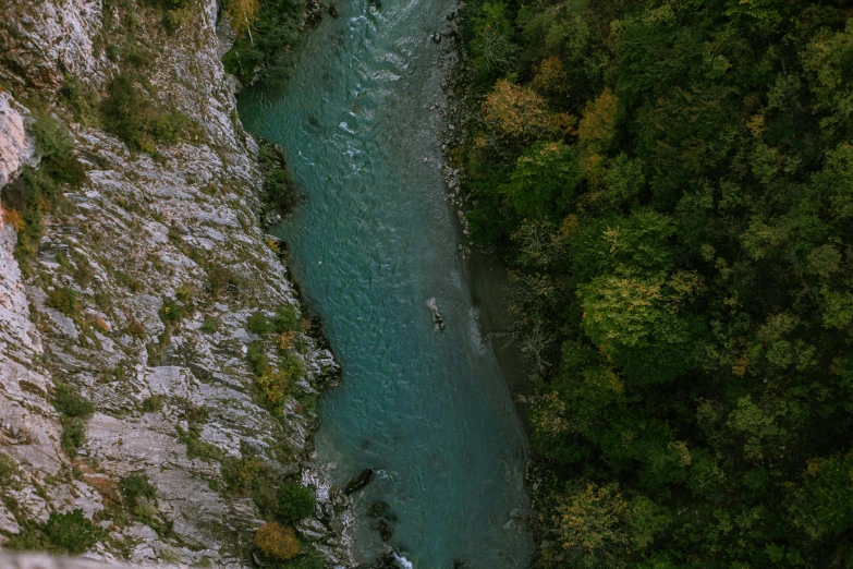 a man standing on top of a cliff next to a river, pexels contest winner, hurufiyya, green grasse trees and river, aerial footage, 3 boat in river, slovenian