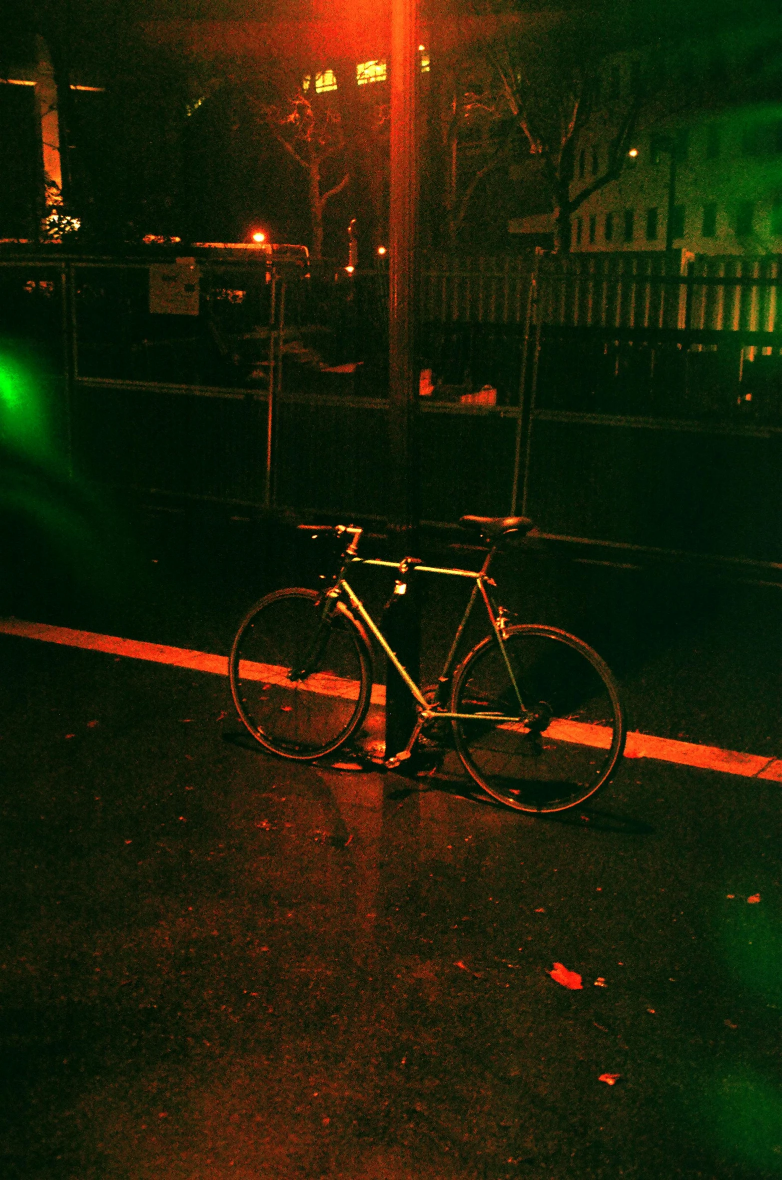 a bicycle parked on the side of the road at night, an album cover, inspired by Elsa Bleda, vivid green lasers, fuji superia, gold, medium - shot