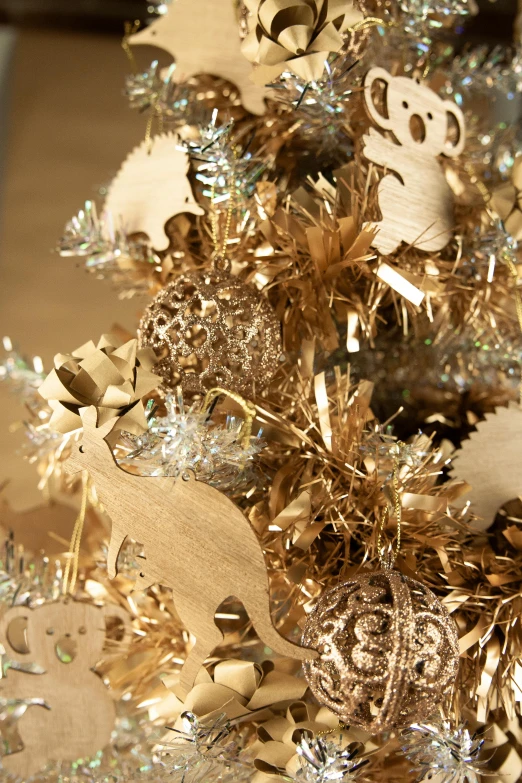 a christmas tree decorated with gold and silver decorations, laser cut textures, zoomed in, cardboard, gold colours