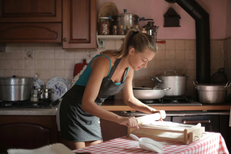 a woman in a kitchen preparing food on a table, italian looking emma, profile image, food. craft and adventure, square