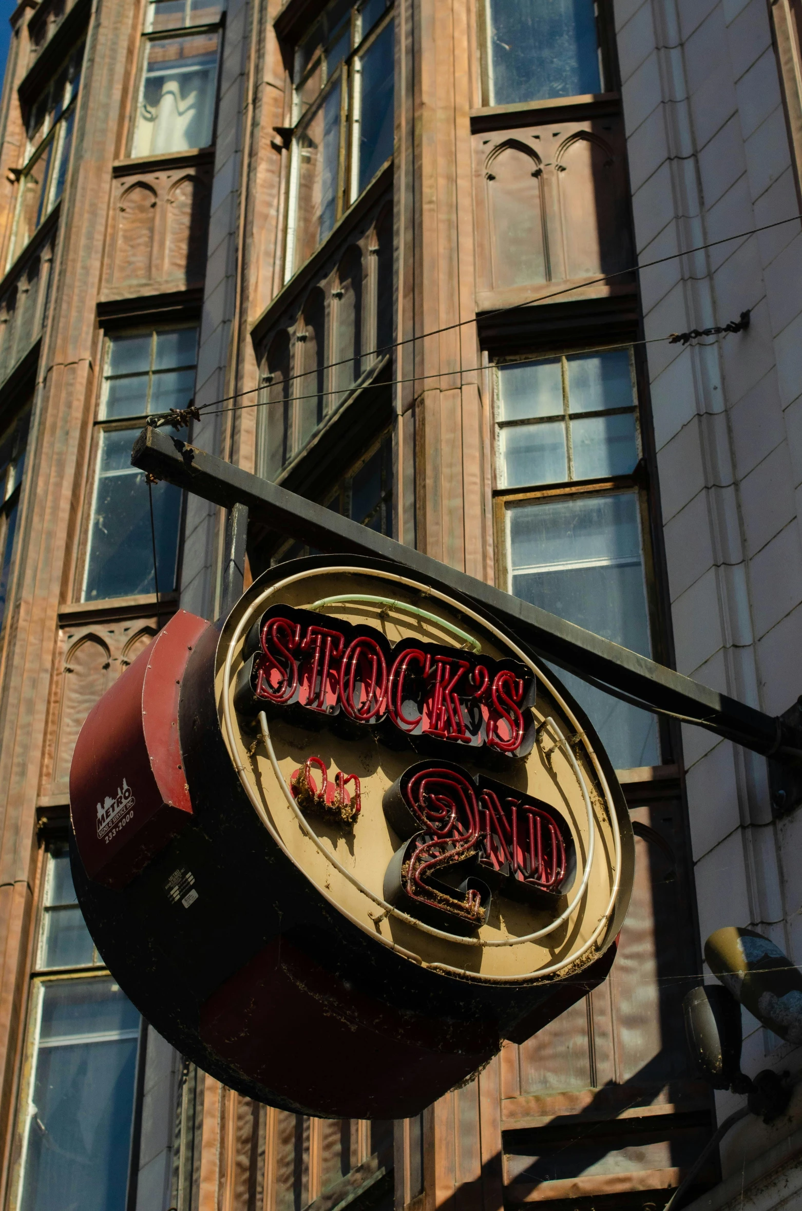 a large clock hanging from the side of a building, stuckism, jackstraws, old signs, slick!!, slightly drunk