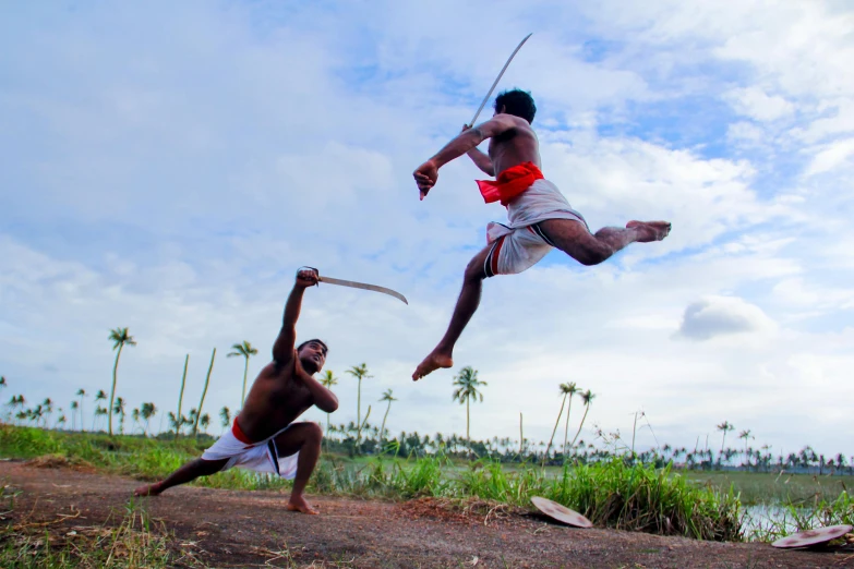 a couple of men standing on top of a dirt field, an album cover, by Daryush Shokof, pexels contest winner, hurufiyya, doing martial arts, malayalis attacking, tribal art, thumbnail