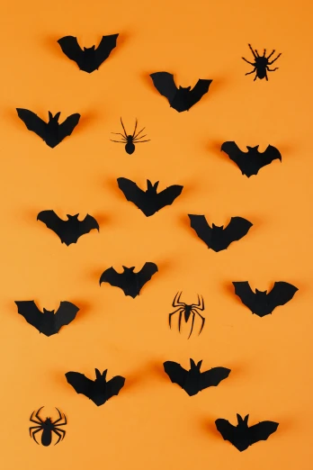 a group of bats hanging on a wall, trending on pexels, conceptual art, in front of an orange background, hero shot, papercut, bl