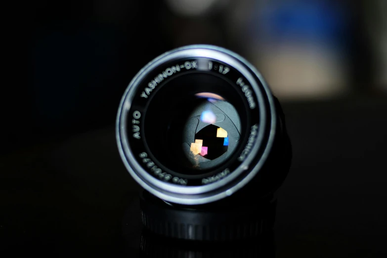 a close up of a camera lens on a table, unsplash, photorealism, medium format. soft light, aperture f12, lens flair, anon 5 0 mm
