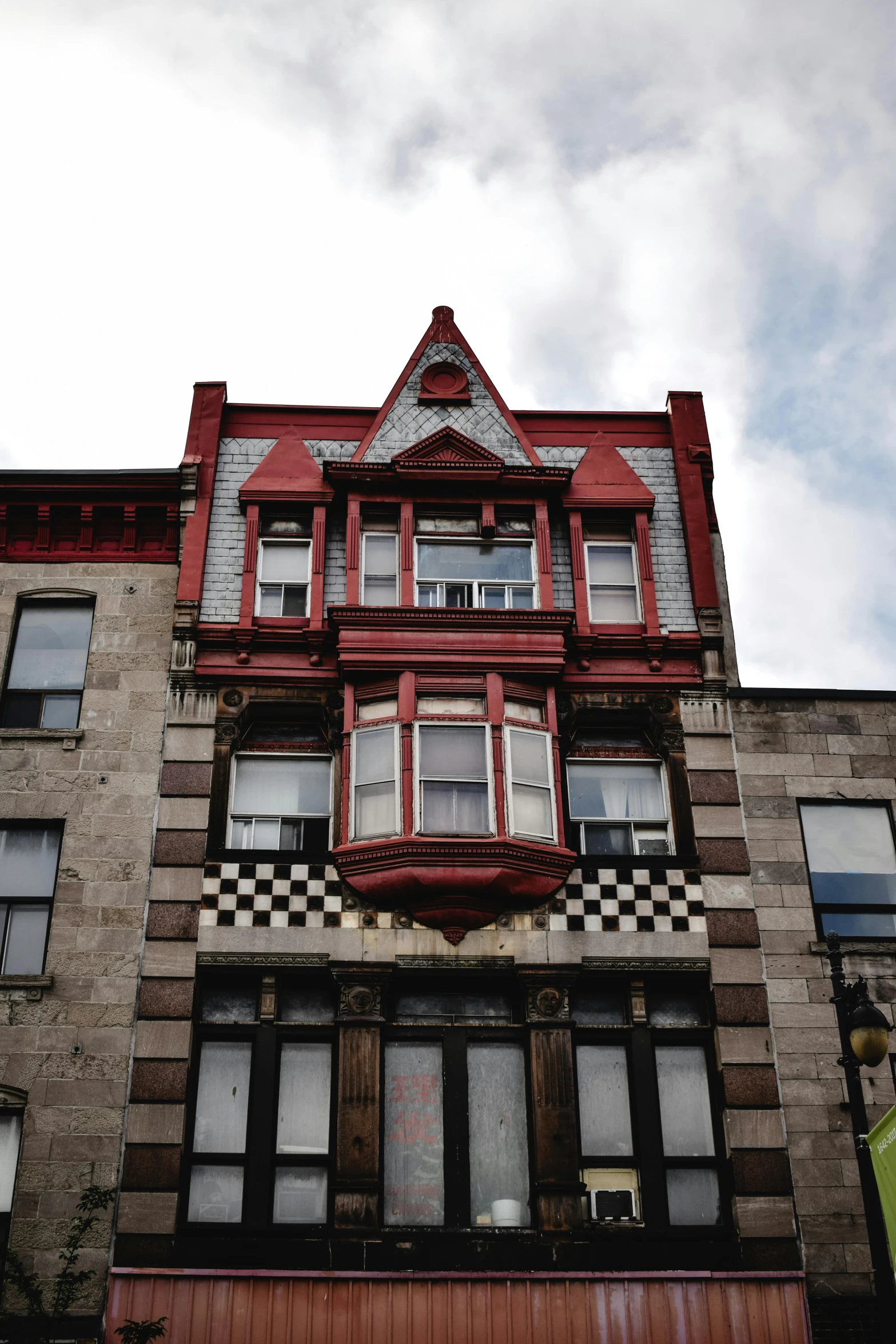 a tall building with a clock on the front of it, a photo, inspired by Jodorowsky, trending on unsplash, art nouveau, wine red trim, bay window, harlem, red white and black color scheme