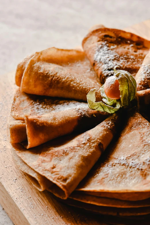 a close up of a plate of food on a table, pancakes, on a wooden tray, cone shaped, chiffon