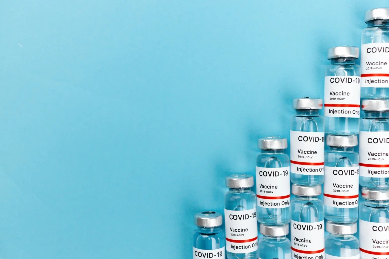 a bunch of vials sitting on top of each other, with a blue background, syringe, high quality product image”, background image