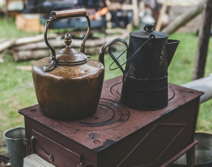 a couple of kettles sitting on top of a stove, pexels contest winner, figuration libre, rustic setting, upcycled, brown, medium closeup