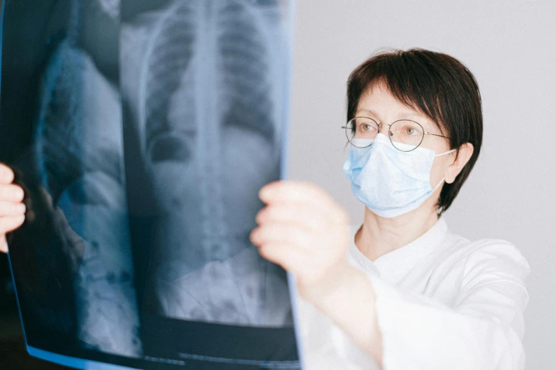 a woman wearing a face mask looking at an x - ray, pexels contest winner, shin hanga, rib cage, 15081959 21121991 01012000 4k, with a stethoscope, long chin